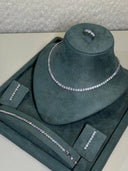 Bridal wedding jewelry set with tennis necklace, matching bracelet, slim earrings and zircon ring displayed on stand