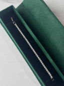 Elegant rhodium plated tennis bracelet with brilliant cubic zirconia stones displayed on luxury jewelry packaging