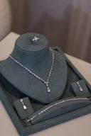 Bridal wedding jewelry set with teardrop necklace, matching bracelet, drop earrings and teardrop ring displayed on stand