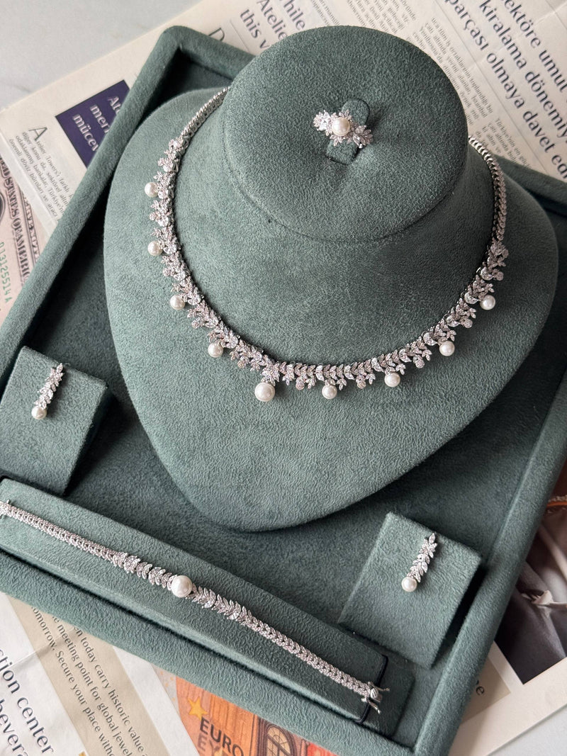 Full bridal jewelry set with pearl necklace bracelet earrings and ring displayed together