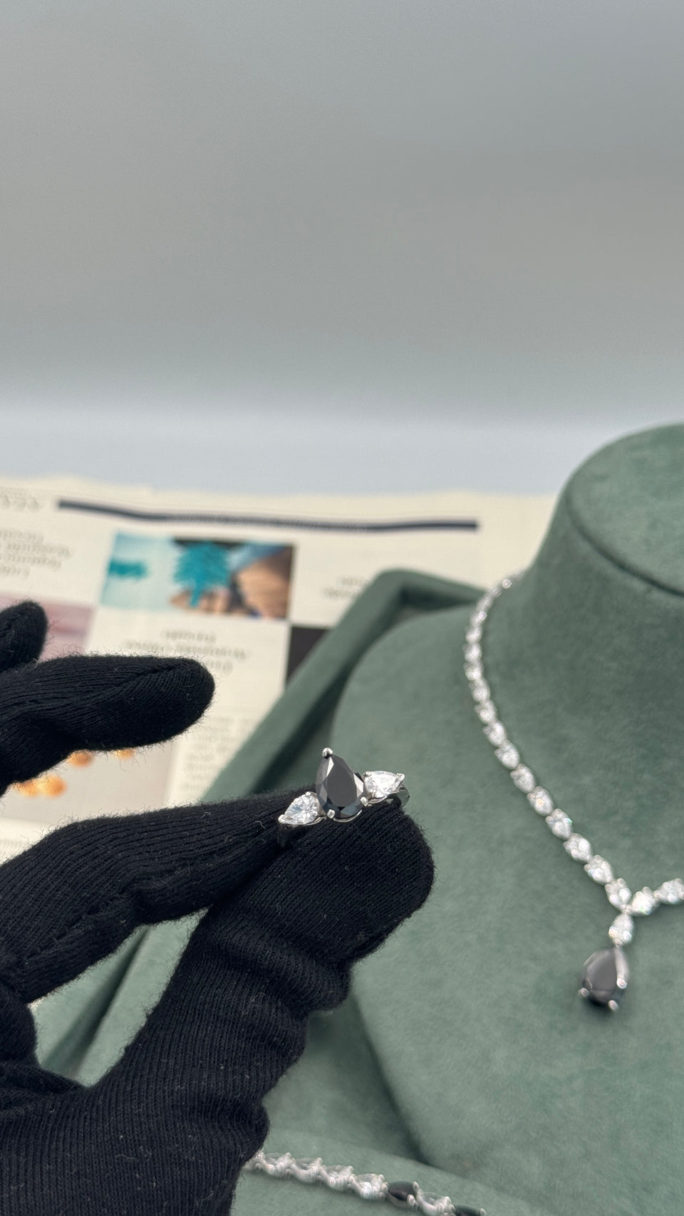 Adjustable bridal ring with a black pear cut center and two clear pear cut side stones