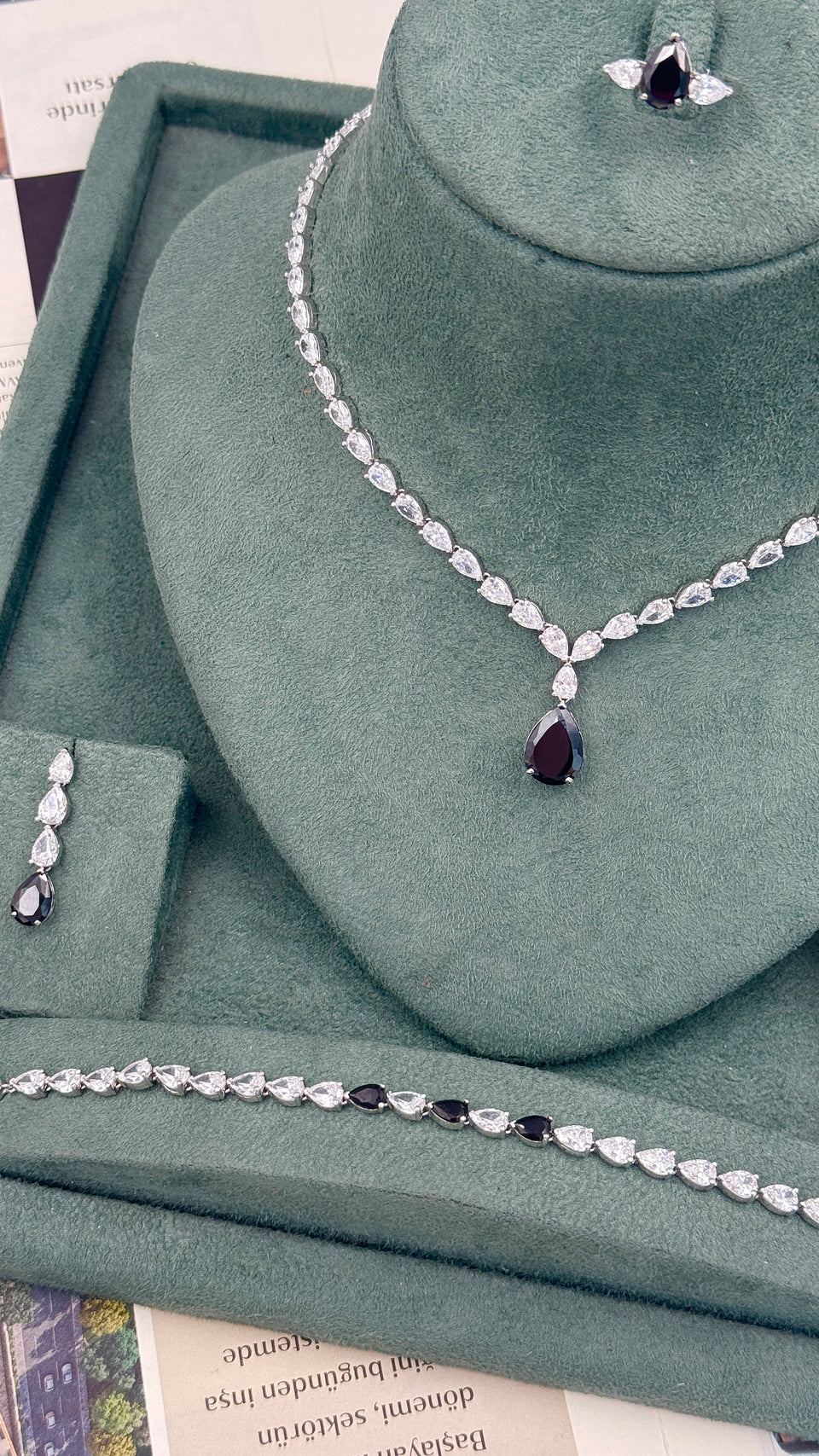 Pear cut bridal jewelry set with a black teardrop necklace earrings tennis bracelet and adjustable ring