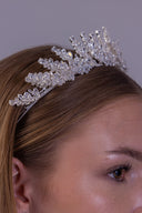 Floral bridal crown worn by a bride, featuring silver zircon flowers and raised botanical branches for an elegant wedding look.