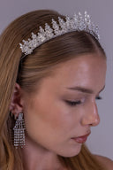 Silver zircon bridal tiara worn by a bride, featuring floral clusters and raised leaf branches for an elegant wedding crown look.