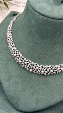 Close-up of a botanical bridal necklace featuring white pearls, marquise zircon leaves and small baguette details