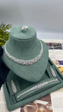 Complete pearl bridal set displayed with a wide botanical necklace, two floral earrings, matching bracelet and adjustable ring