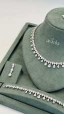 Close view of a clear pear cut teardrop fringe statement bridal necklace with a matching bracelet and earring
