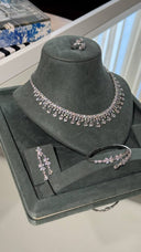 Clear zircon bridal jewelry set displayed with a statement collar necklace, earrings, open cuff bracelet and ring