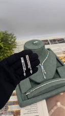Pair of double-row zircon bridal earrings held in front of a matching Y necklace, tennis bracelet and ring