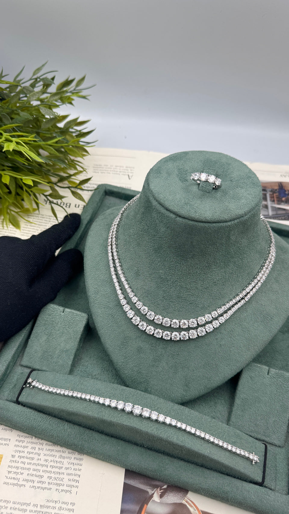 Silver bridal set displayed with a double-row tennis necklace, graduated bracelet and five-stone ring