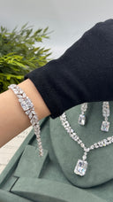 Marquise leaf bridal bracelet with a large emerald-cut zircon center worn on the wrist beside the matching wedding jewelry set