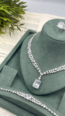 Close view of an emerald-cut bridal pendant necklace with a matching marquise zircon bracelet and statement ring