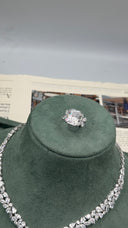 Close-up of an adjustable bridal statement ring with a large clear emerald-cut zircon center and marquise side stones
