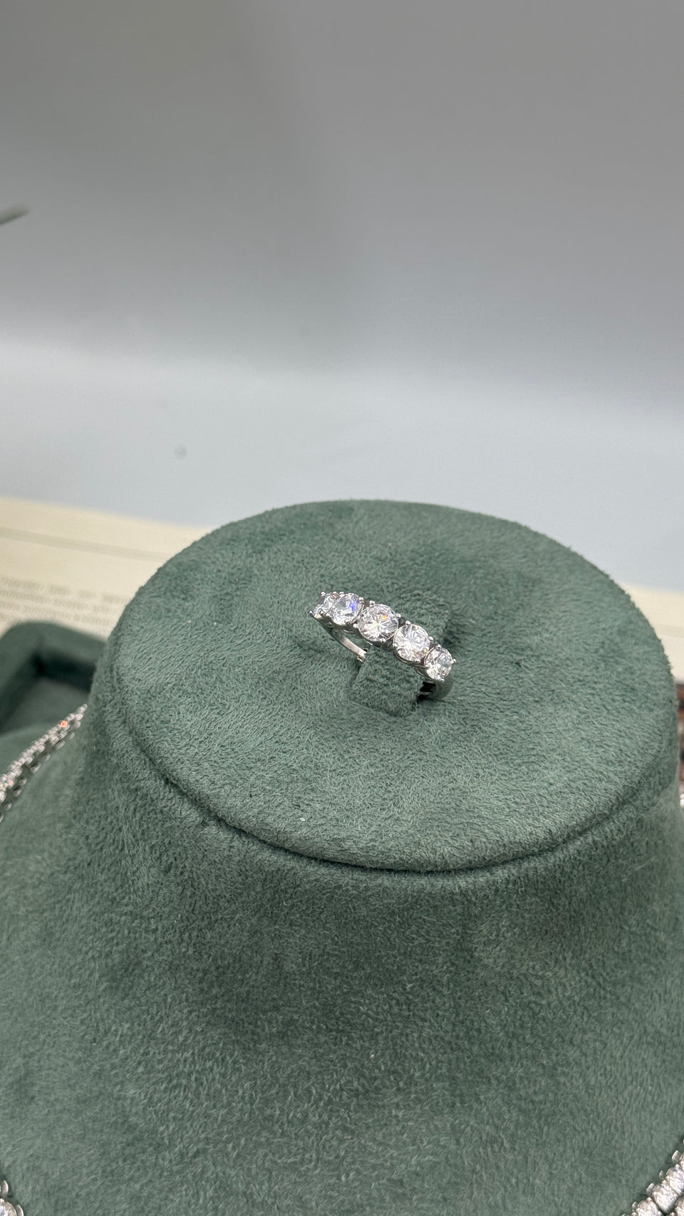 Close-up of an adjustable silver bridal ring with five graduated round-cut clear zircon stones