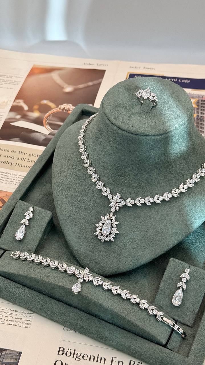 Complete four-piece bridal jewelry set with floral leaf necklace, pear-drop earrings, bracelet and adjustable ring