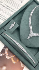 Detailed bridal jewelry display showing one floral drop earring, graduated leaf bracelet and matching marquise V necklace