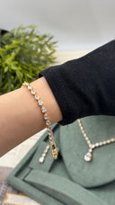 Gold-plated pear-cut zircon bridal bracelet worn on the wrist with the matching wedding necklace and earring behind
