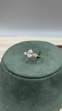 Close-up of an adjustable gold-plated bridal ring with a large pear-cut zircon center and two matching side stones