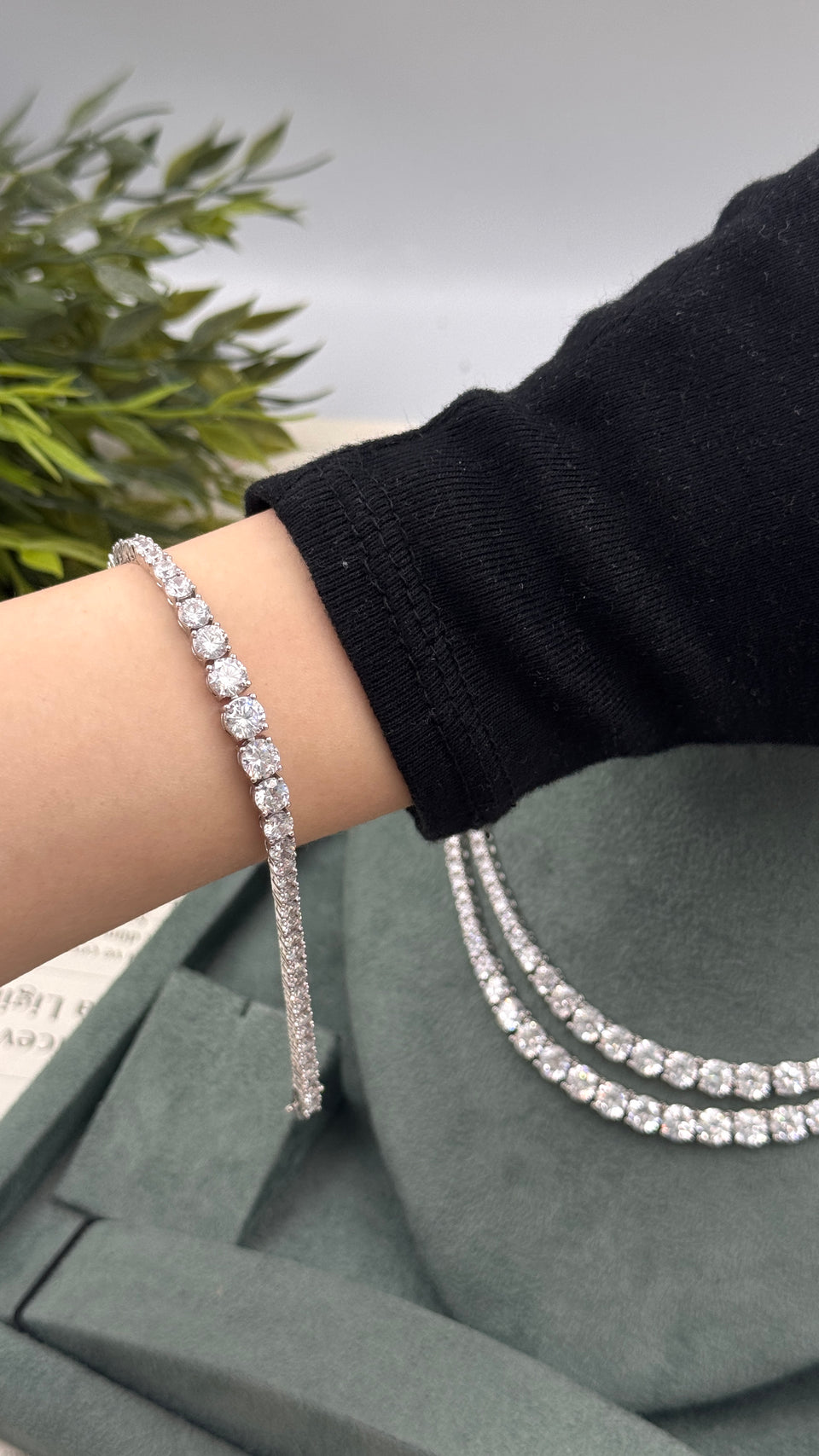 Graduated round-cut zircon tennis bracelet worn on the wrist with the matching double-row bridal necklace behind