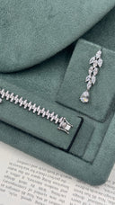 Close-up of one marquise leaf bridal drop earring beside the secure box clasp of the matching zircon bracelet
