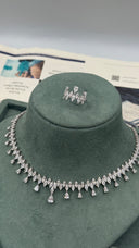 Detailed display of a clear zircon bridal necklace, one marquise leaf drop earring and matching teardrop fringe bracelet