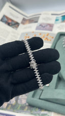 Back view of a marquise zircon bridal bracelet and its secure box clasp held over a black glove
