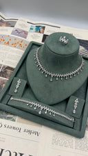 Four-piece clear zircon bridal wedding jewelry set displayed with a marquise leaf fringe necklace, drop earrings, bracelet and adjustable ring