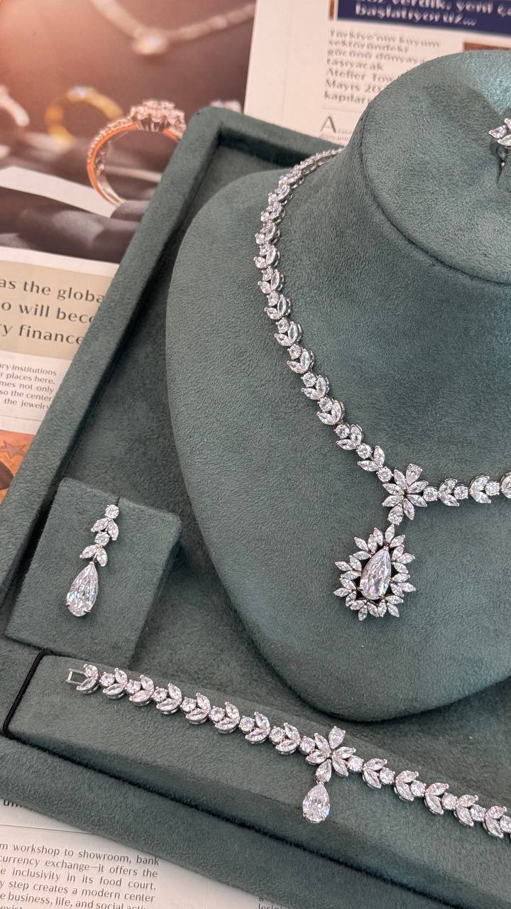 Silver bridal jewelry set with a pear-cut floral leaf necklace, matching drop earring, bracelet and adjustable ring