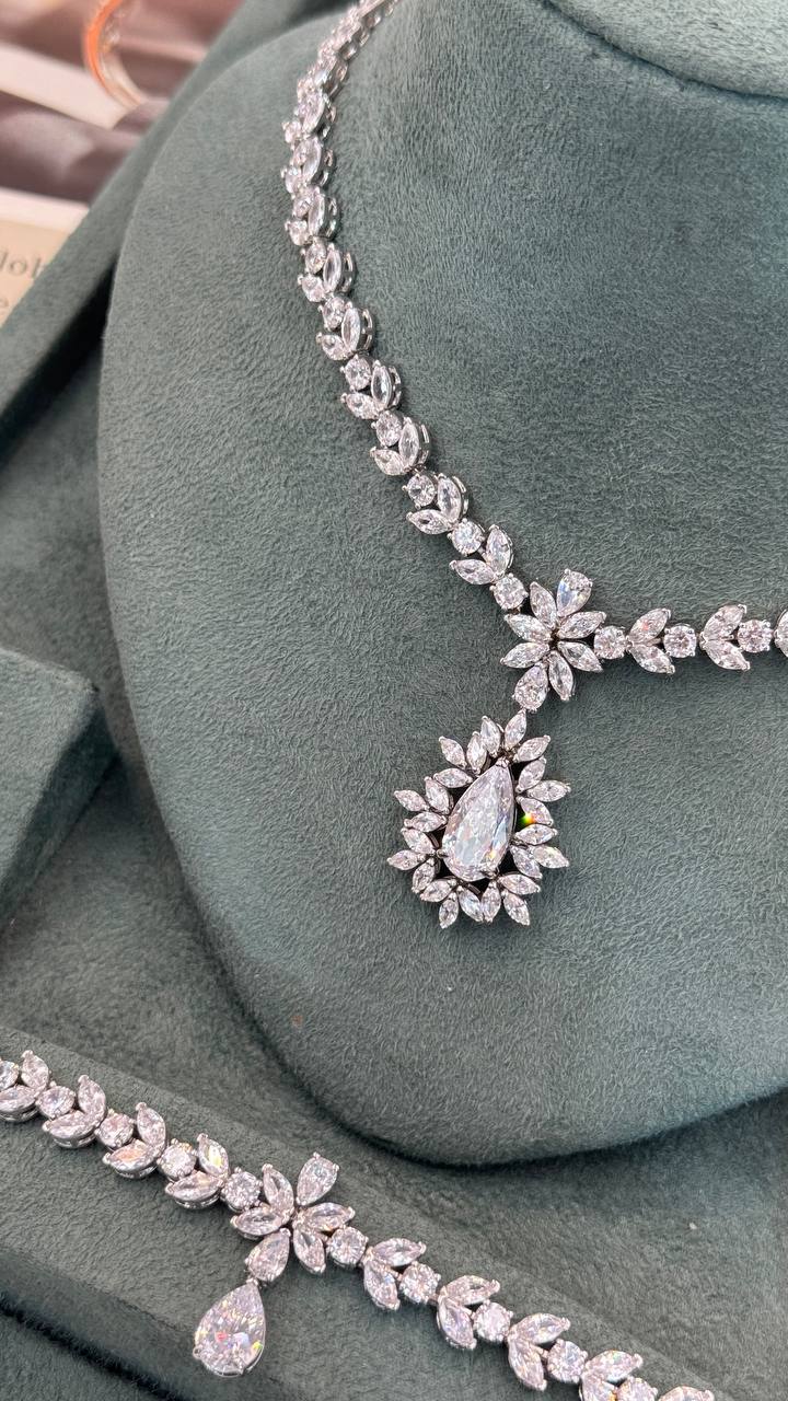 Detailed pear-cut bridal necklace pendant surrounded by marquise zircon leaves with a matching floral bracelet
