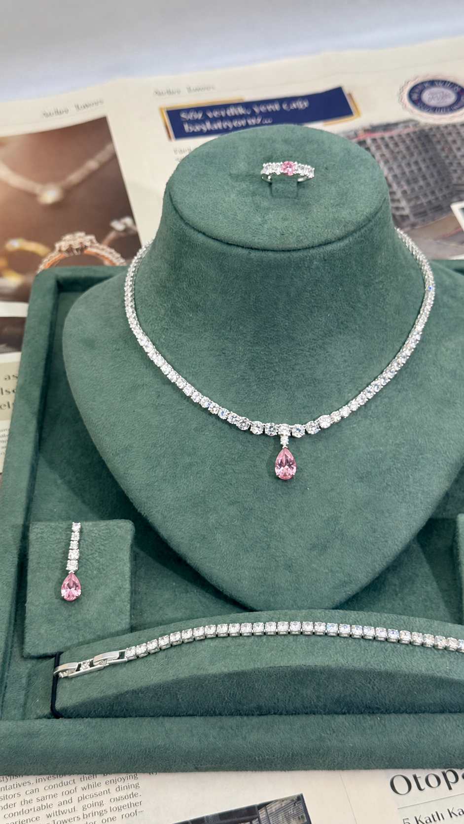Complete four piece bridal jewelry set with pink teardrop tennis necklace matching earrings tennis bracelet and adjustable ring