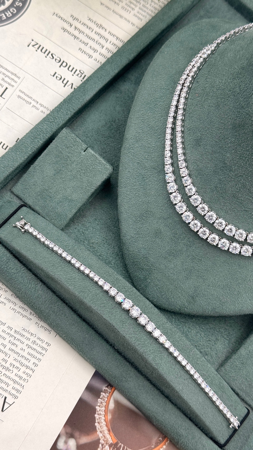 Close-up of a double-row round zircon wedding necklace beside a matching graduated tennis bracelet