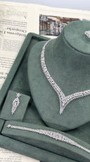Close view of a marquise leaf V-shaped bridal necklace with one matching floral drop earring and graduated zircon bracelet