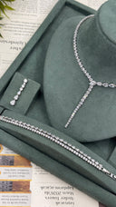Y-shaped bridal necklace displayed with one teardrop earring and two matching zircon bracelets for a wedding