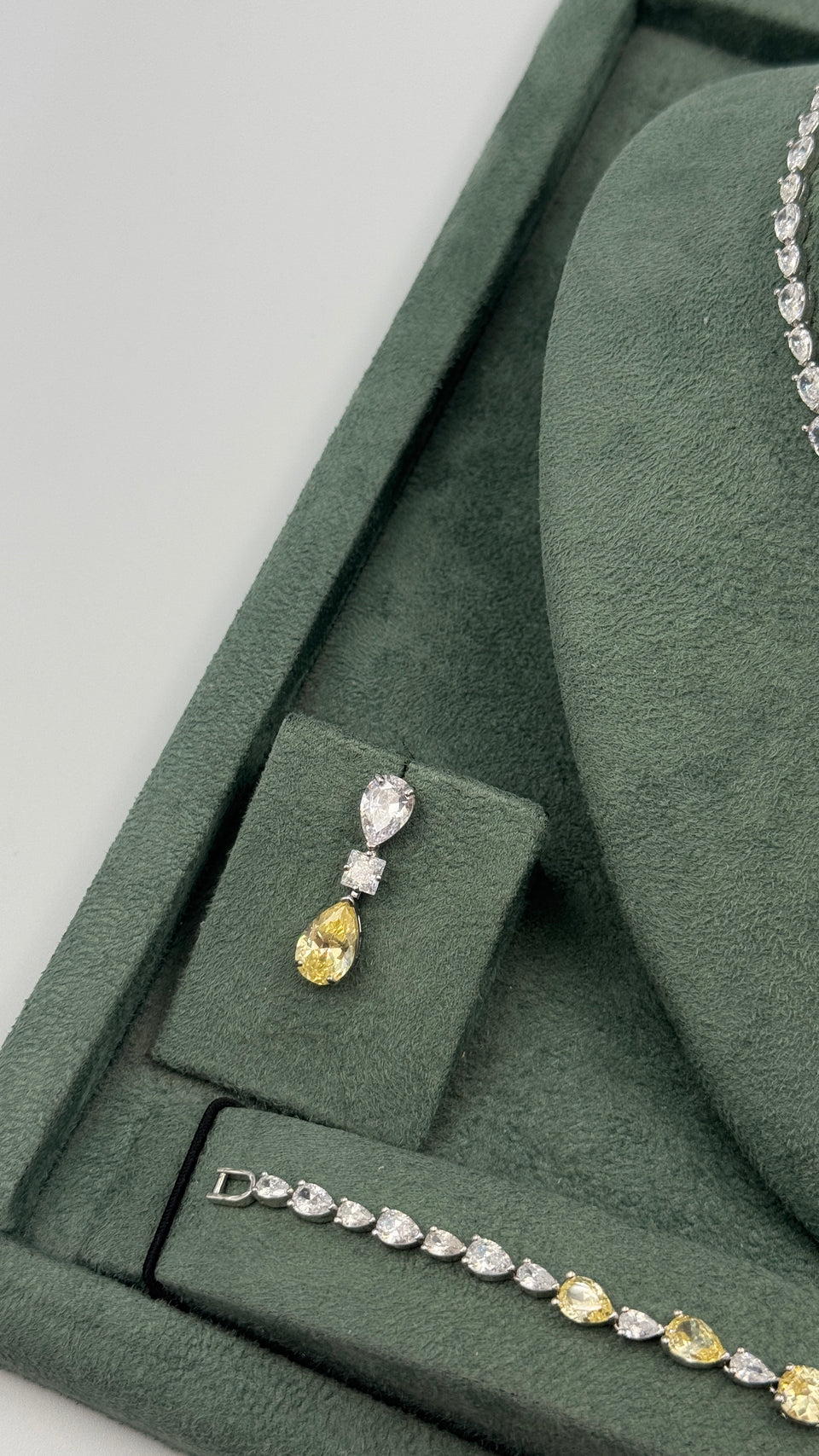 Yellow pear-drop bridal earring displayed beside a matching two-tone zircon tennis bracelet