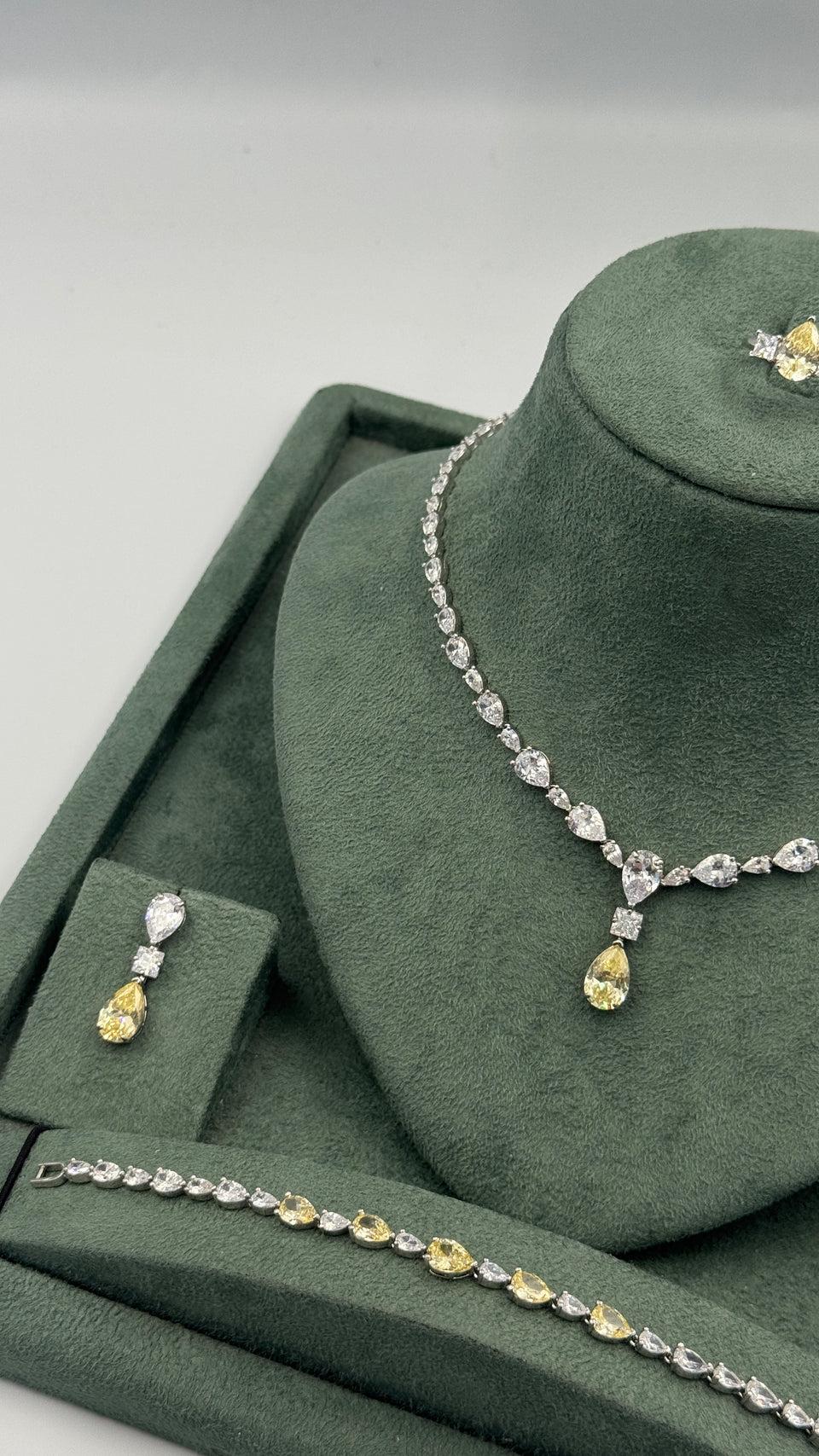 Clear and yellow zircon wedding set featuring a graduated tennis necklace, drop earring, bracelet and ring