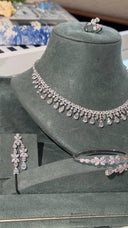 Close-up of a clear zircon bridal collar necklace with teardrop fringe, matching earrings, cuff bracelet and ring