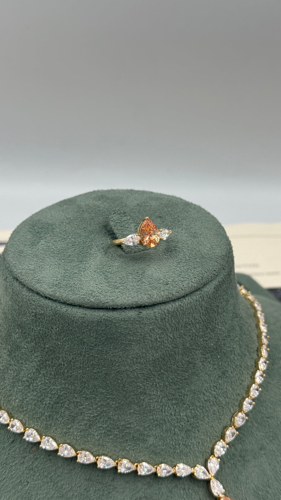 Adjustable gold plated bridal ring with a champagne pear cut center and two clear pear cut side stones