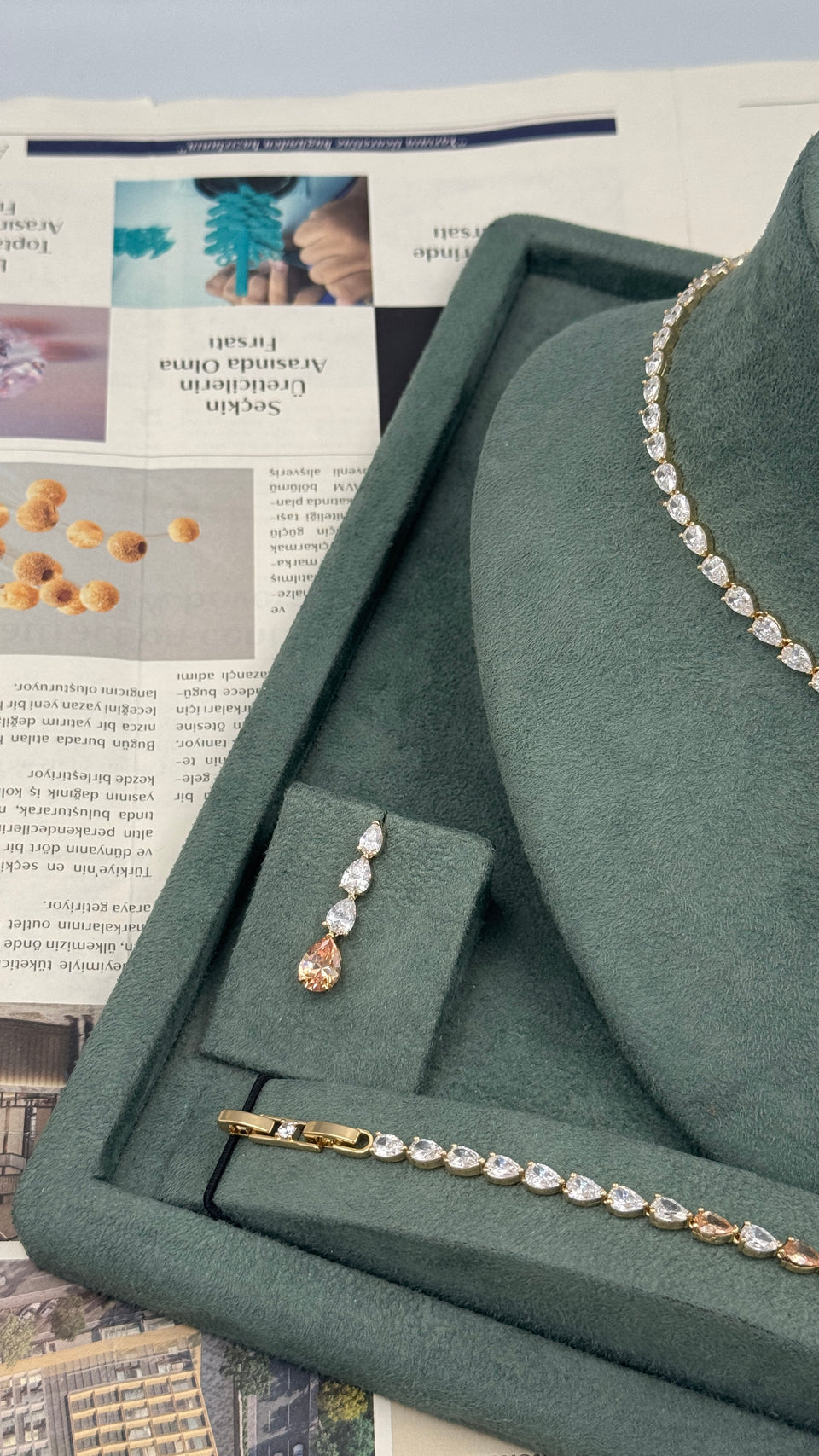 Champagne pear drop bridal earring beside a matching gold plated pear cut tennis bracelet