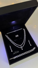 Complete bridal jewelry set presented in a black gift box with layered necklace earrings bracelet and ring