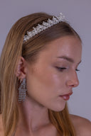 Delicate pearl wedding tiara shown from the side, with clear faceted leaves and a softly raised center for an elegant bride.