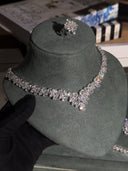 Silver necklace on a gray mannequin bust with books in the background