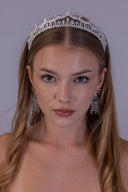 Profile view of a silver-plated bridal crown with structured geometric patterns and clear zircon accents arranged across the frame.