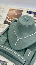 Necklace on a green velvet stand with a newspaper underneath