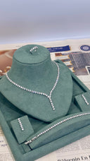 Silver necklace on a green velvet stand with newspaper background