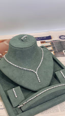 Jewelry set on a green mannequin bust with a newspaper background