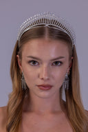 Front view of a bride wearing a luxury silver zircon bridal crown with a tall, symmetrical sunburst wedding tiara design