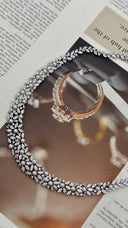 Luxury pearl wedding necklace laid flat to show its marquise zircon leaves, baguette accents and open botanical pattern