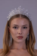 Luxury silver zircon bridal crown worn by a bride, featuring an elevated center and sparkling teardrop stones for a royal wedding look