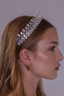 Silver zircon bridal crown worn by a bride, featuring symmetrical teardrop stones and marquise leaves for a radiant wedding look.