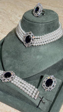 Close-up bridal choker with layered pearls and navy gemstone centerpiece